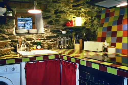 - une cuisine avec un évier et un mur en pierre dans l'établissement Casa Rural Sobre Fábulas, à Prádena de Atienza