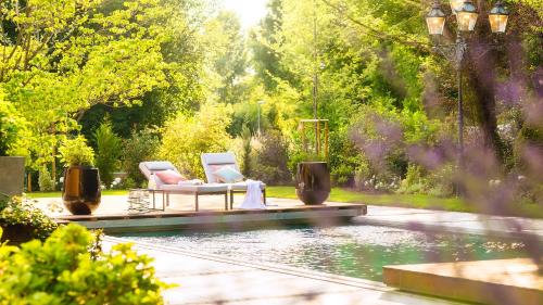two chairs sitting next to a pool in a garden at Zeller-Hotel+Restaurant in Kahl am Main