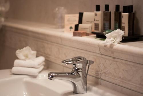 a bathroom sink with a faucet and towels on a shelf at Hotel Slunce in Uherské Hradiště