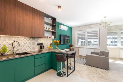 a kitchen with turquoise cabinets and a counter top at WawelSee Apartments in Krakow