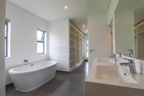 a white bathroom with a large tub and a sink at Robertson Halfway House in Robertson