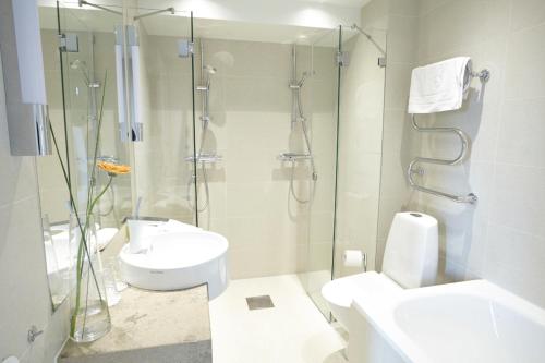a bathroom with a shower and a toilet and a sink at Elite Stadshotellet Växjö in Växjö