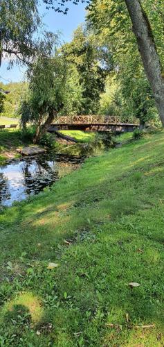 a bridge over a river in a grass field at Kisa Wärdshus & Hotell in Kisa