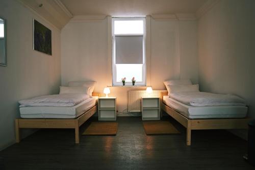 two beds sitting in a room with a window at Pension & Monteurwohnungen Burglesum Bremen in Bremen