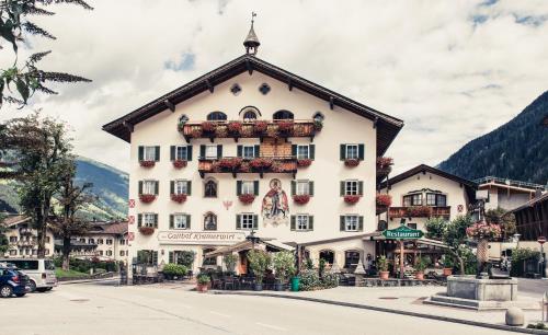 a large white building with flowers on the front at Alpenhotel Kramerwirt in Mayrhofen