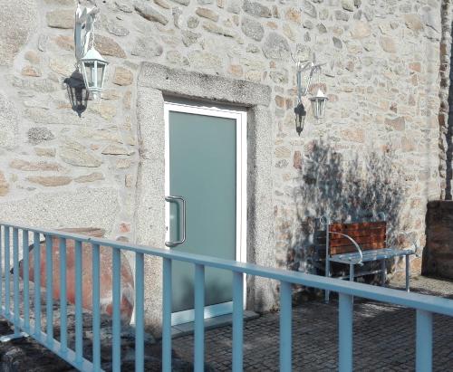 a door in a stone building with a blue railing at Casa do Vale da Mula in Almeida