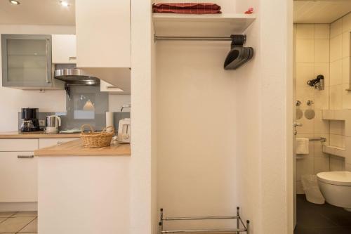 une cuisine avec une porte menant à une salle de bains. dans l'établissement Gästehaus Heinemann - Eg3, à Langenargen