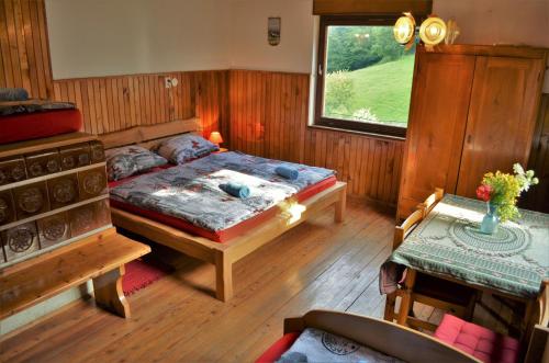 a bedroom with a bed and a table and a window at Healing Farm in Gorenja Vas