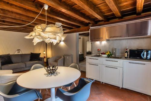 フィレンツェにあるMDR Duomo Apartmentのテーブルと椅子のあるキッチンとリビングルーム