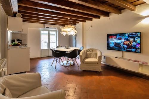 フィレンツェにあるMDR Duomo Apartmentのリビングルーム(テーブル、椅子、テレビ付)