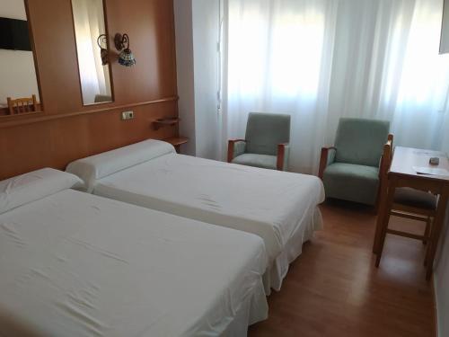 a hotel room with two beds and two chairs at Hotel Aro'S in Casas Ibáñez