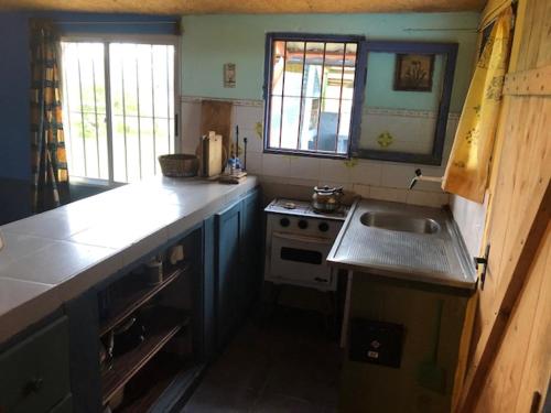 cocina pequeña con fregadero y fogones en La Azurra, en Barra de Valizas