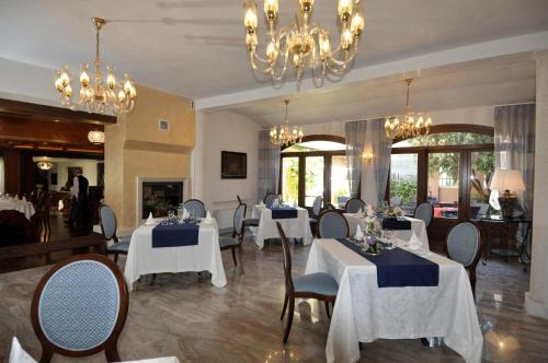 Hotel Aldo Moro في مونتاغنانا: مطعم بطاولات بيضاء وكراسي وثريات
