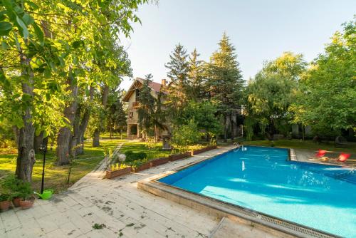 einen Blick über einen Pool in einem Garten mit Bäumen in der Unterkunft SUNOLUS VINEYARDHOUSe in Kayseri