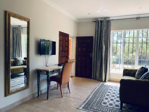 a living room with a table and a mirror at At The Rocks Country Estate in Avondzon