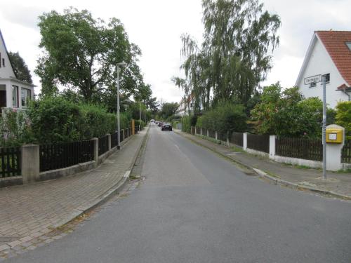 an empty street with a car driving down the road at Großes Privatzimmer in Messenähe in Hannover