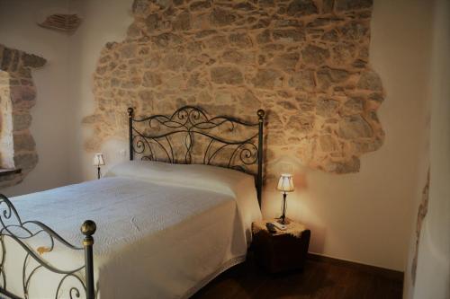 una camera con letto e parete in pietra di B&B Le Fate a Sonnino