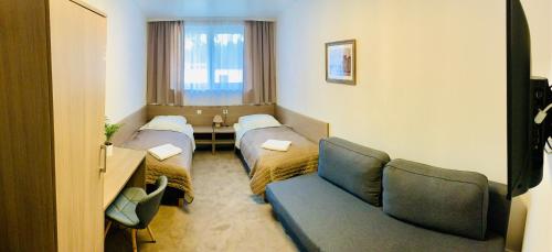 a hospital room with two beds and a couch at Gościniec Skwierzyna in Skwierzyna