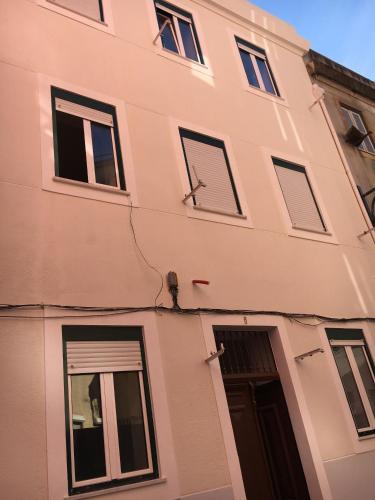 a pink building with windows and a door at Vila Queirós, 6 in Lisbon