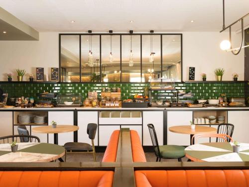 ein Restaurant mit Tischen und Stühlen und eine Küche in der Unterkunft Aparthotel Adagio Brussels Grand Place in Brüssel