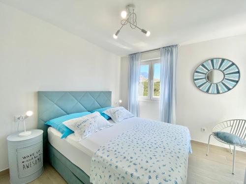 - une chambre avec un lit bleu et blanc et une fenêtre dans l'établissement Apartmani Ksenija, à Tučepi