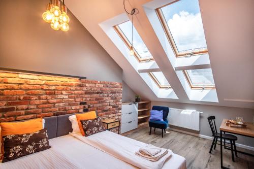 a bedroom with skylights and a brick wall at Szpitalna 9 Residence in Kraków