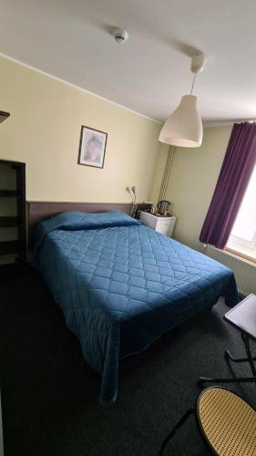 a bedroom with a blue bed with a blue comforter at hotel Melissa in Péruwelz