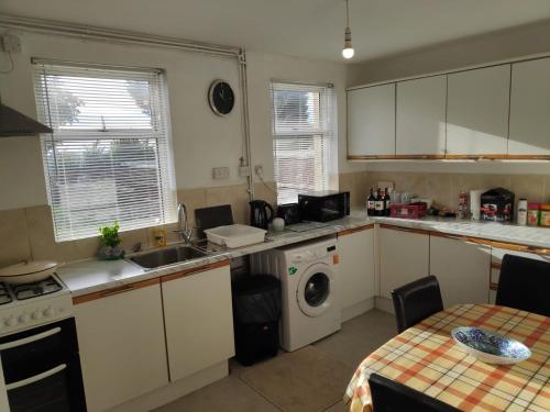 a kitchen with a sink and a washing machine at Worcester Town Home & Garden in Hindlip