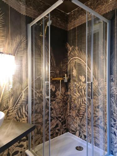 a bathroom with a shower with a wall covered in wallpaper at The Henry Self Check-In Guesthouse in Zürich