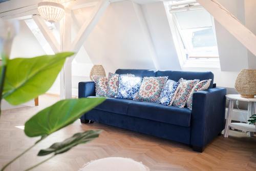 a blue couch with pillows in a living room at The Henry Self Check-In Guesthouse in Zürich