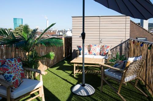 a patio with a table and chairs and an umbrella at The Henry Self Check-In Guesthouse in Zürich