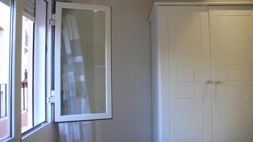 a mirror on the wall next to a door at Apartamento Portalet 7 in Benaguacil
