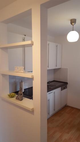 a kitchen with white cabinets and a teddy bear sitting on a counter at Eldenhof in Plau am See