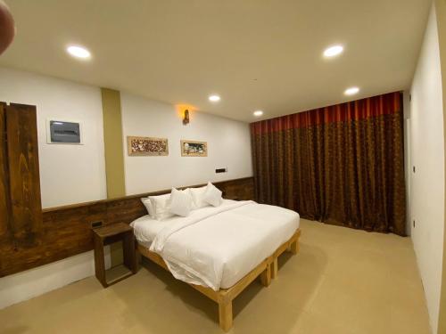 a bedroom with a white bed and a window at Rindali - The speedboat from Malé to the hotel departs at 1130 every Monday Thursday and Saturday and from the hotel to Malé at 0630 and five domestic flights are available every day in Dhaalu Atoll