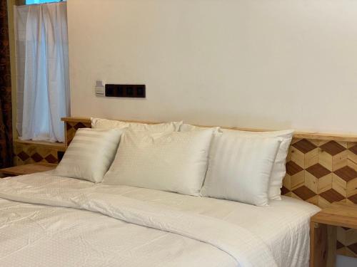 a bed with white pillows on top of it at Rindali - The speedboat from Malé to the hotel departs at 1130 every Monday Thursday and Saturday and from the hotel to Malé at 0630 and five domestic flights are available every day in Dhaalu Atoll