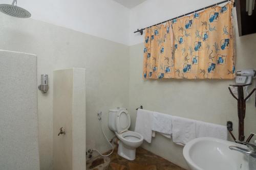 a bathroom with a toilet and a sink at Villa Ameera Malindi in Malindi