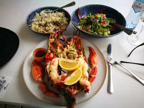 a plate of food with shrimp and a salad at Apartment Qiu lux costa da caparica in Costa da Caparica