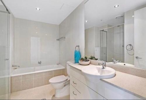 y baño blanco con aseo, lavabo y bañera. en Marina ocean view at The Shores, en Gold Coast