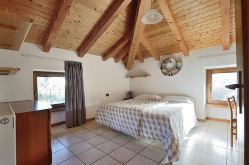 sypialnia z łóżkiem i drewnianym sufitem w obiekcie Residenza Mariella w Arco