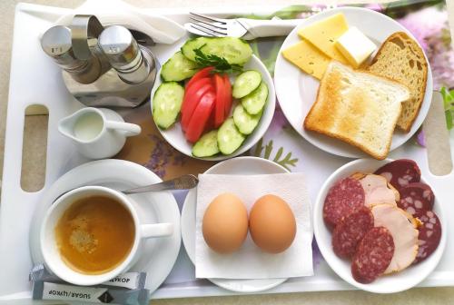 a table with plates of food and a cup of coffee at 7 Sky on Yevhena Konovaltsia in Kyiv