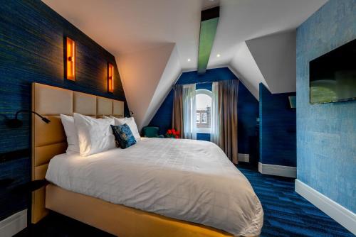 a bedroom with a large bed with blue walls at De Ware Jacob Boutique Hotel in Amsterdam
