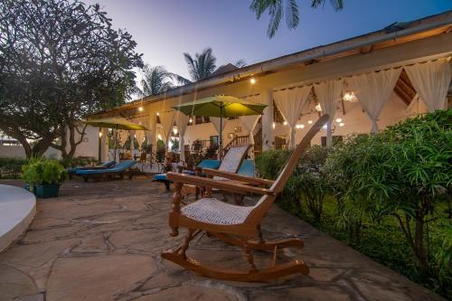 a group of chairs and umbrellas on a patio at Villa Ameera Malindi in Malindi