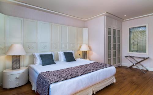 a bedroom with a large white bed and two lamps at Hillstone Bodrum Hotel & Spa in Bodrum City