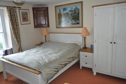 a bedroom with a bed and two night stands and two lamps at Chateau Terrace Georgian House in Chepstow