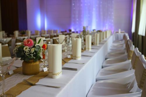 a long table with white linens and flowers on it at Hotel Rezident in Turčianske Teplice