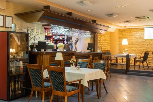 a restaurant with a table and chairs and a bar at Hotel Vaidila in Alytus
