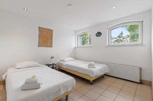 a white room with two beds and a window at Spacious apartment in city center with private patio in Amsterdam