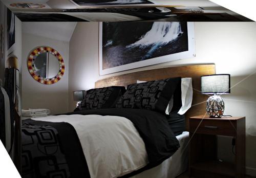 Un dormitorio con una cama en blanco y negro y un espejo en Hostal Chile Chico, en Santiago