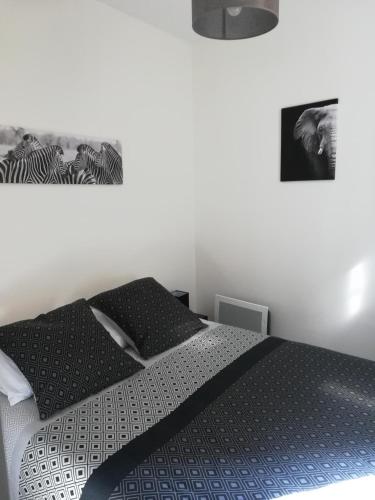une chambre avec un lit avec une couette noire et blanche dans l'établissement Les Néréides, à Mers-les-Bains