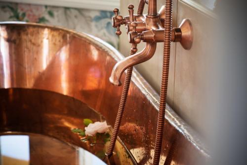 a copper sink in a bathroom with a faucet at Strandflickornas Annex Gula Villan in Lysekil